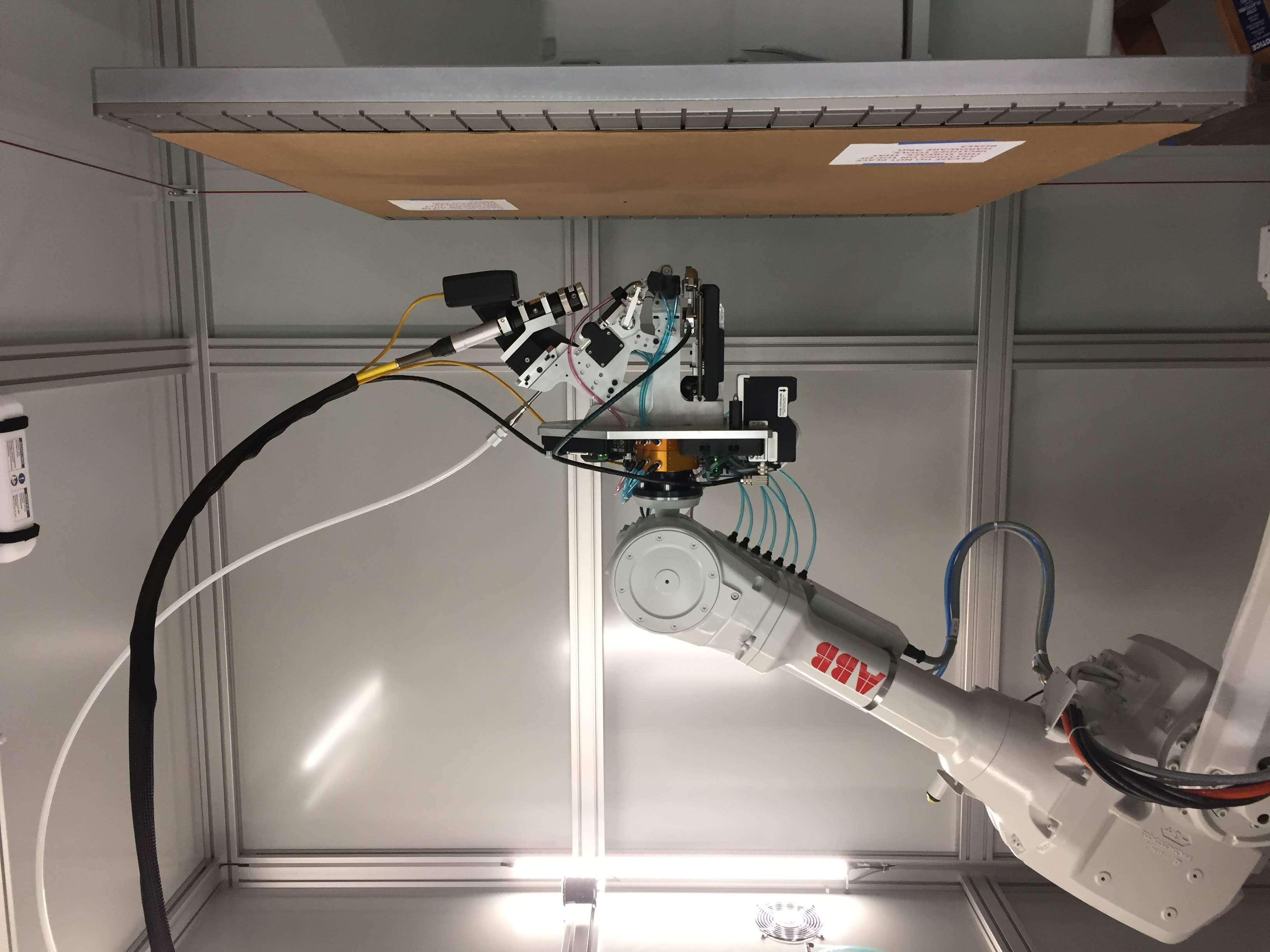 ABB robot arm fitted with a custom continuous carbon-fiber print head end effector
